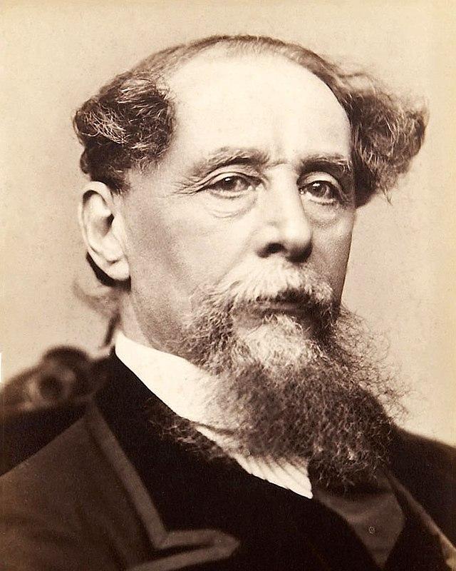 A  man in a black suit with a long beard.