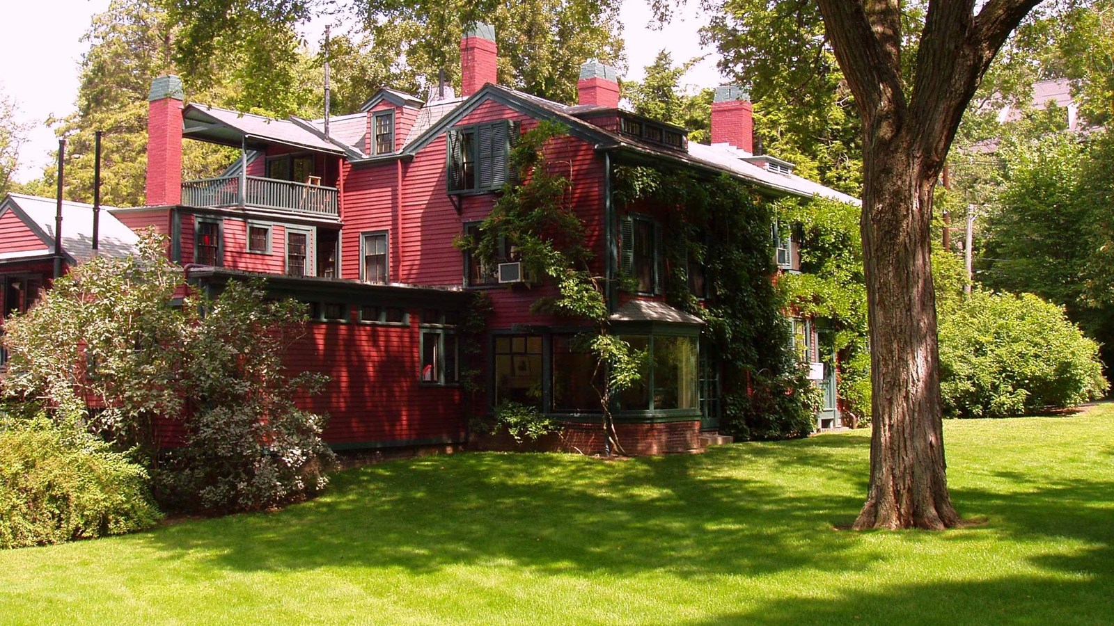 Large red building surrounded by greenery. 