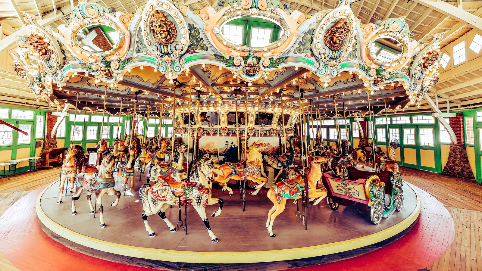 The ornate interior of a carousel, with a variety of hand painted and hand carved animals. 