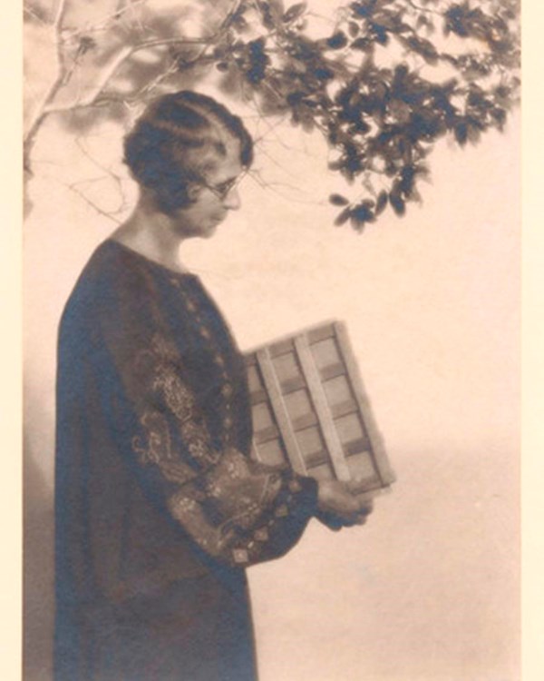 A black and white photo of Ynes Mexia with her plant dryer under a tree