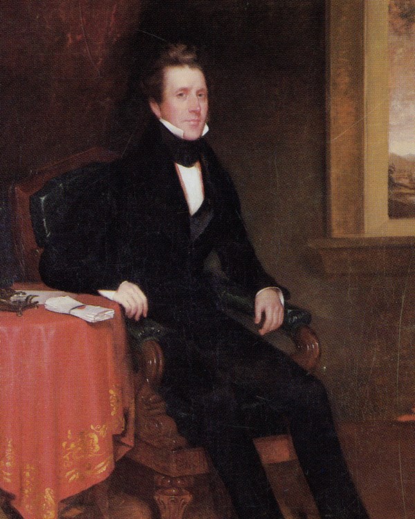 A well dressed man poses to be painted in an ornate chair