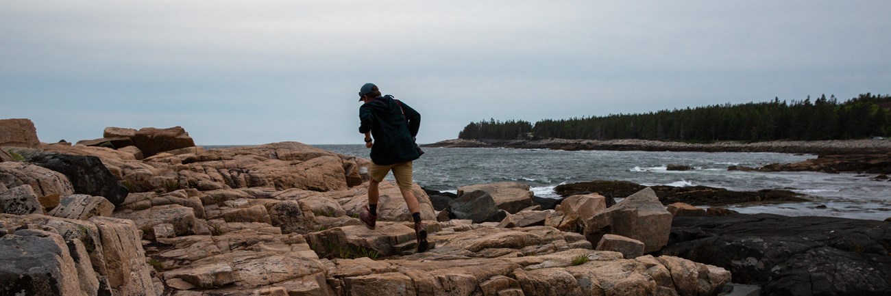 Person walking along rocks on a coastline