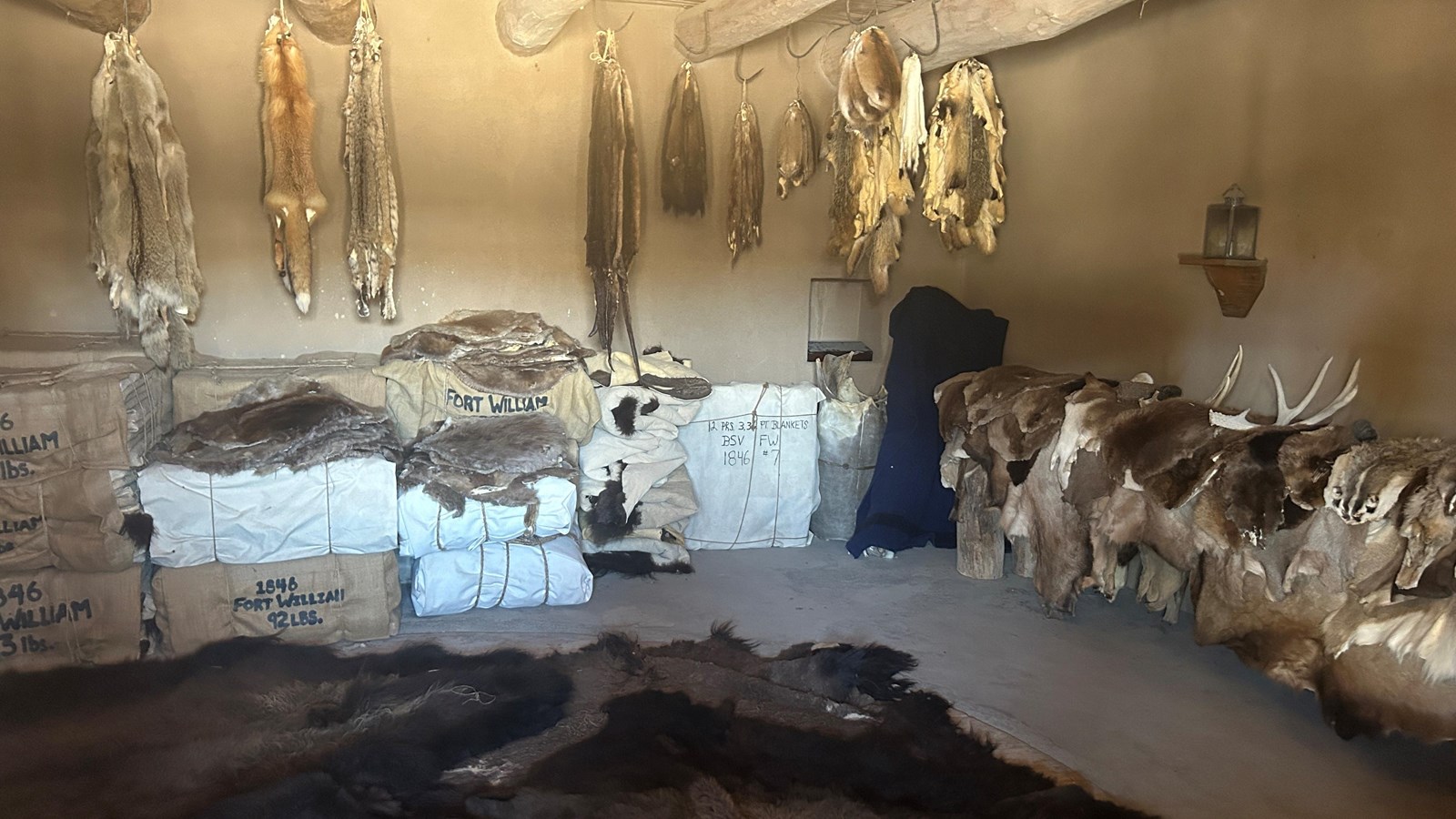 A room full of various animal furs, many bundled for transportation by wagon. 