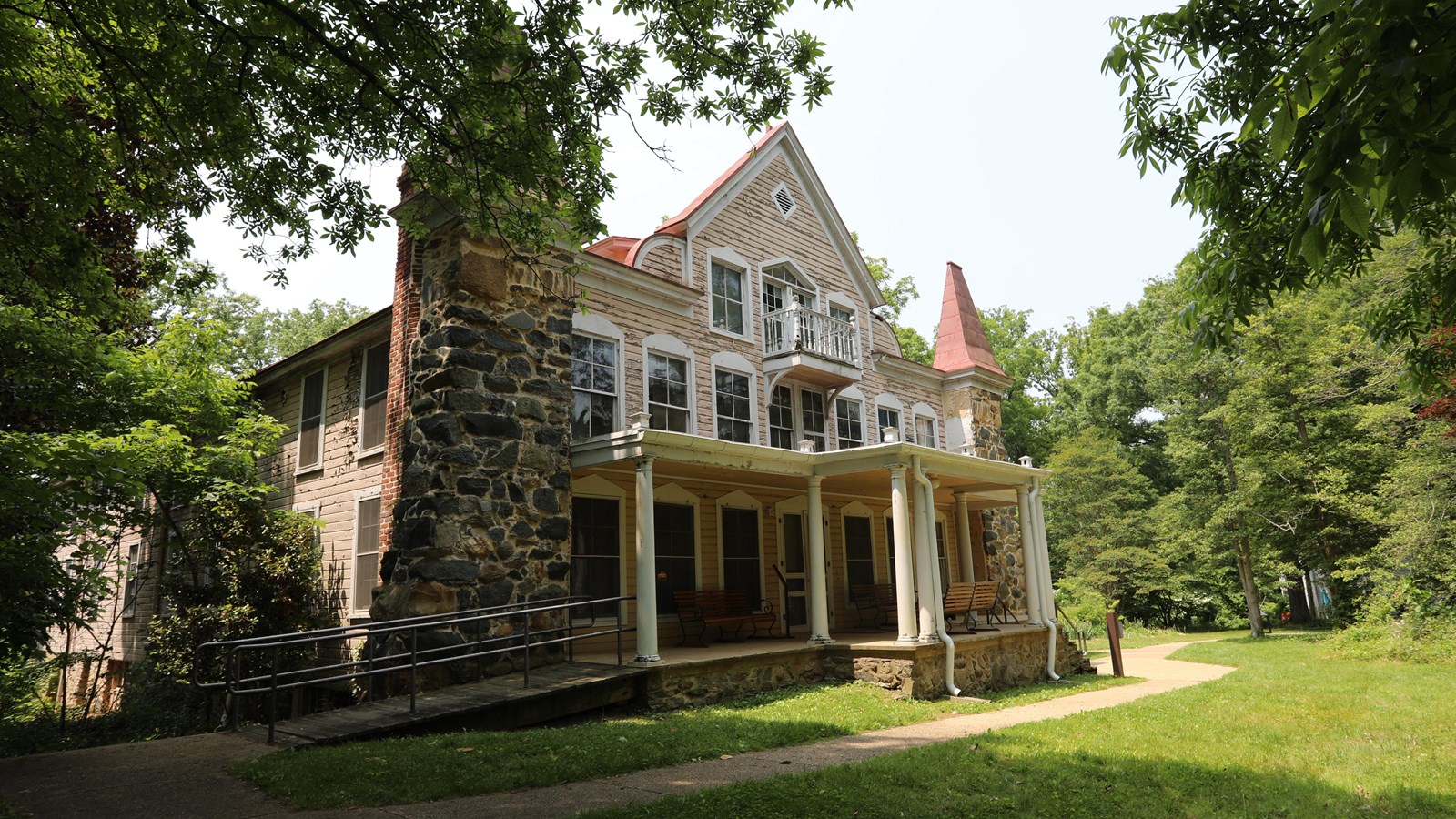 A historic 3-story house with stone turrets on the corners with pointed caps.