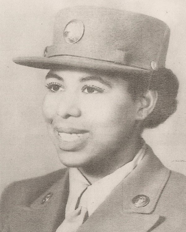 Black and white photo of African American women in World War Two uniforms. She is smiling.