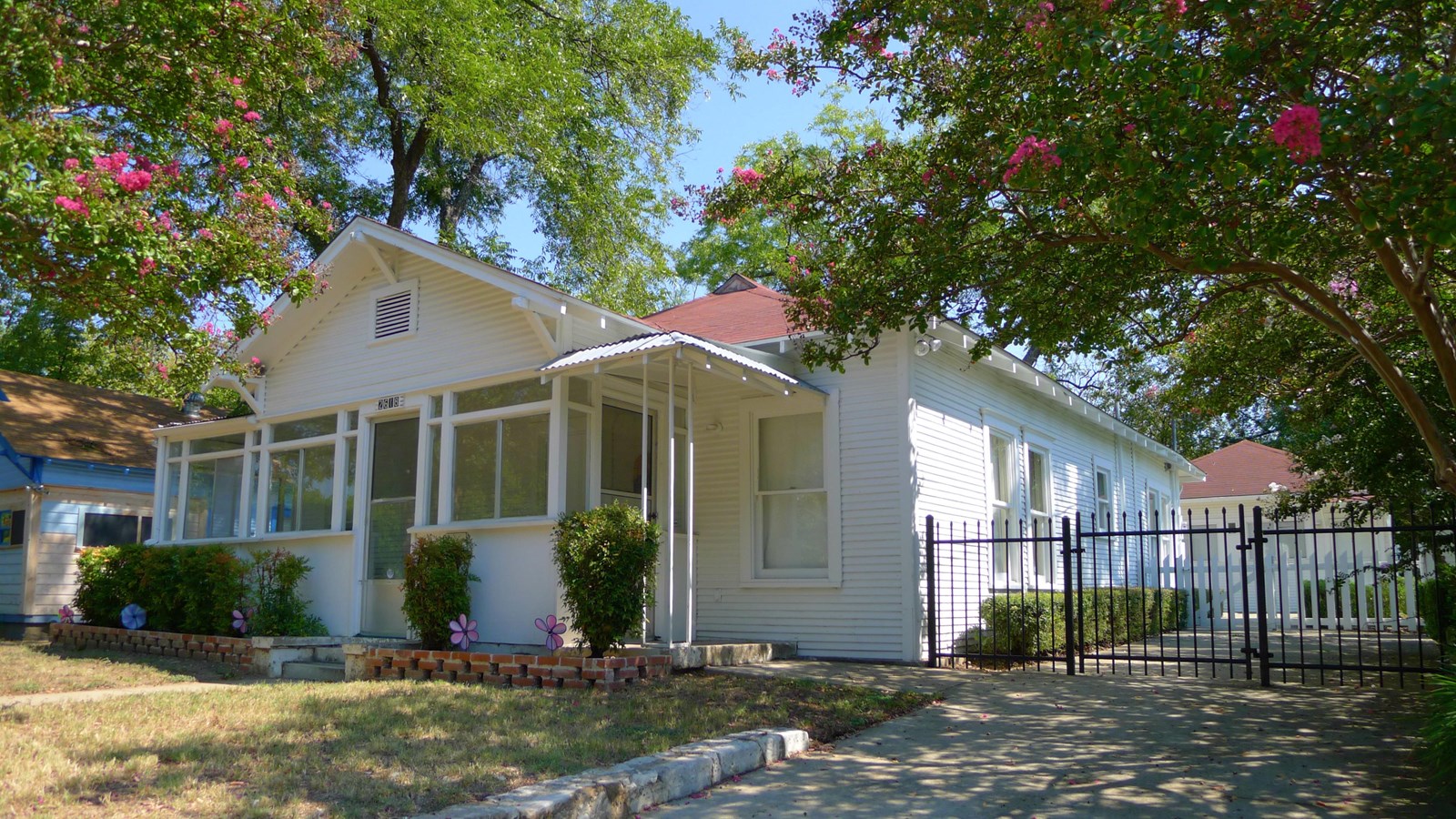 White ranch-style home with small side porch. Photo by Drewp4vp, CC BY-SA 3.0