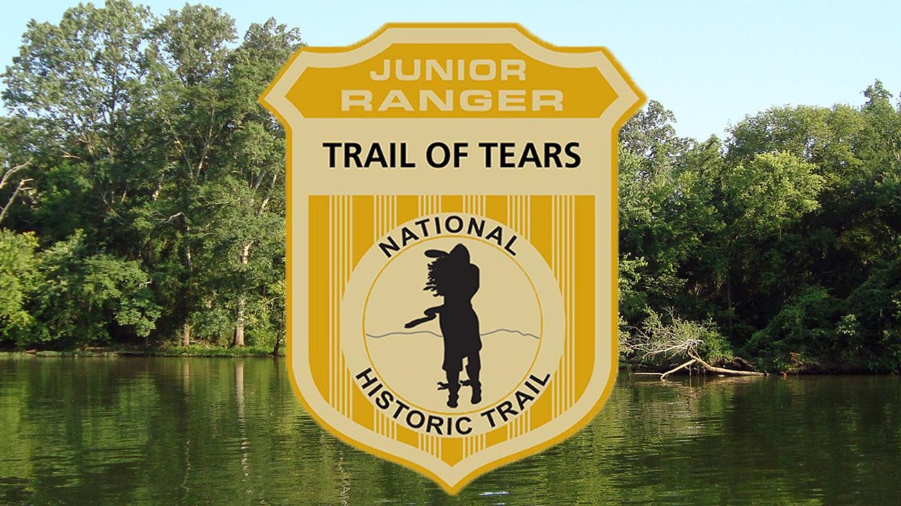 A junior ranger badge over an image of a flat green river with vegetated river banks.