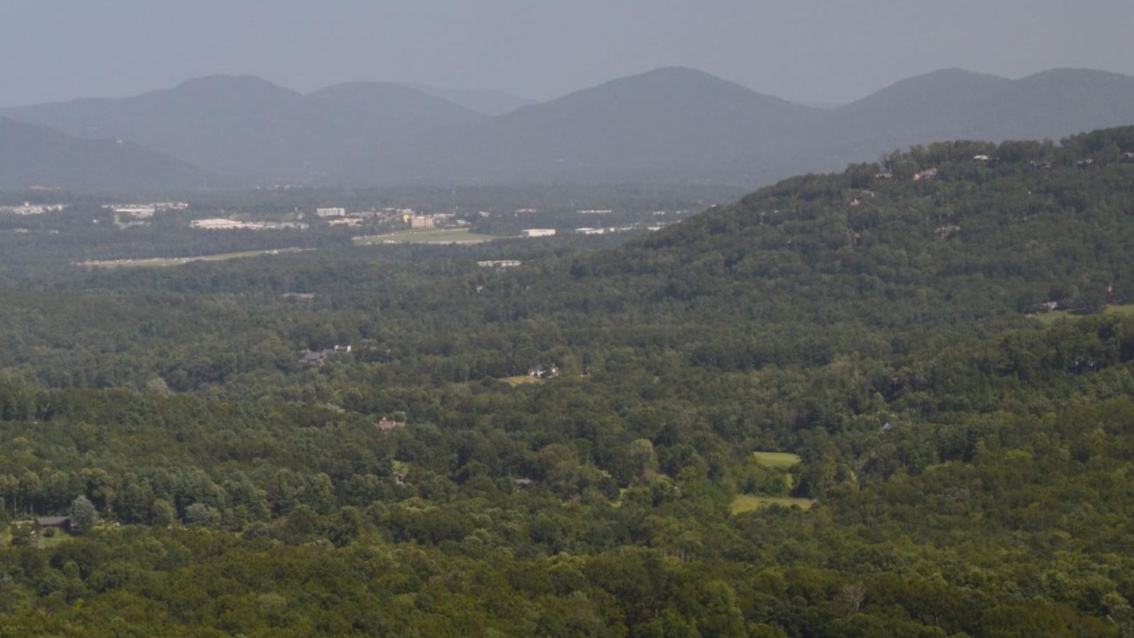 View of green Haw Creek Valley dotted with buildings and mountains in background