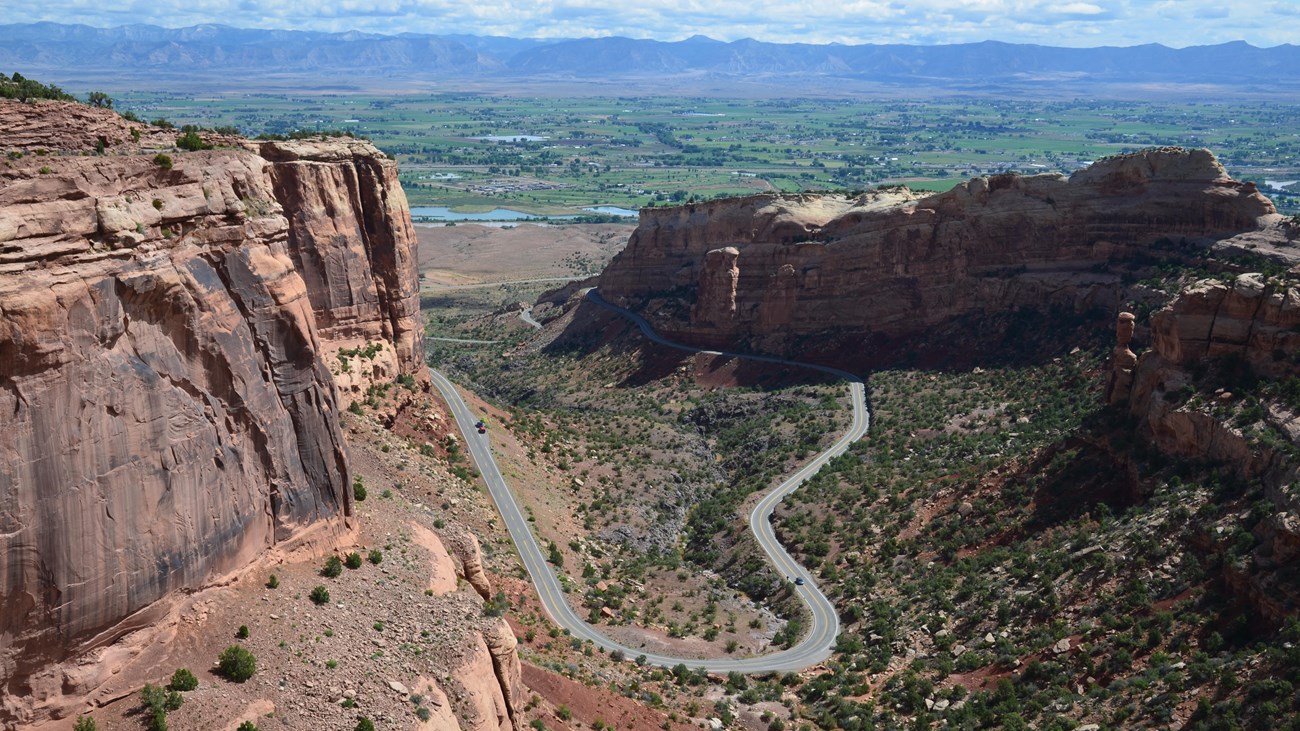 Looking down at road as it curls into and out of red rock canyon.