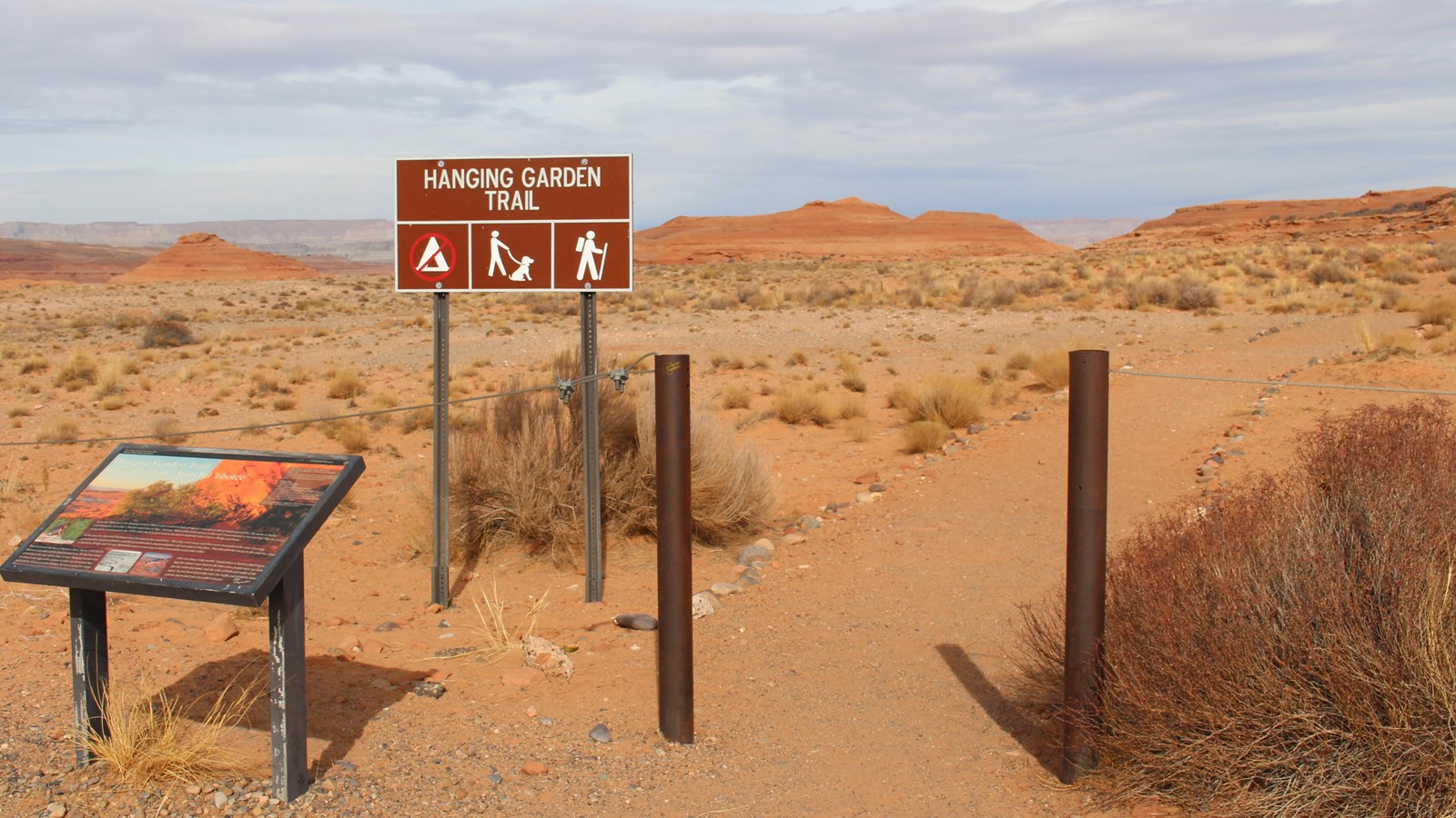 metal posts with walking trail goes through. Sign: 