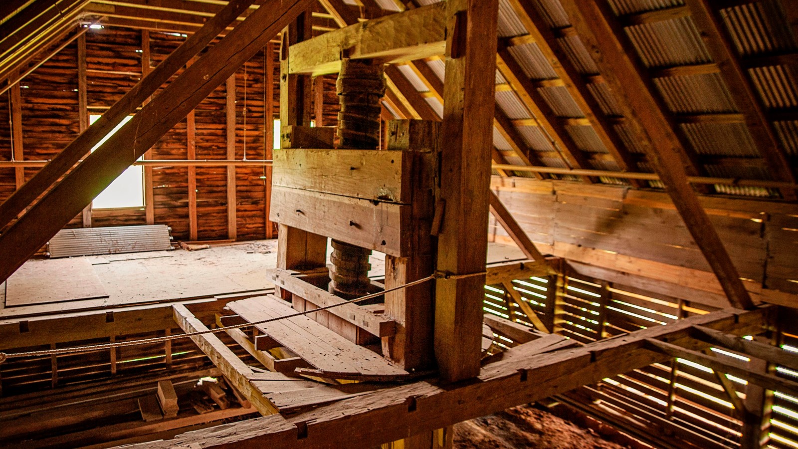 A tall wooden A-frame structure with a center wood screw.