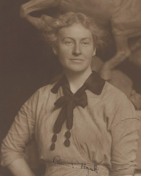 Sepia-tone photograph of Anna Hyatt Huntington. She is a white woman wearing a light-colored dress.