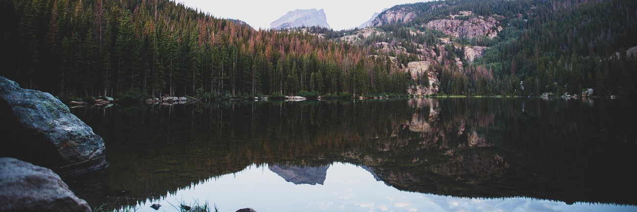 mountain peak reflected in clear calm lake