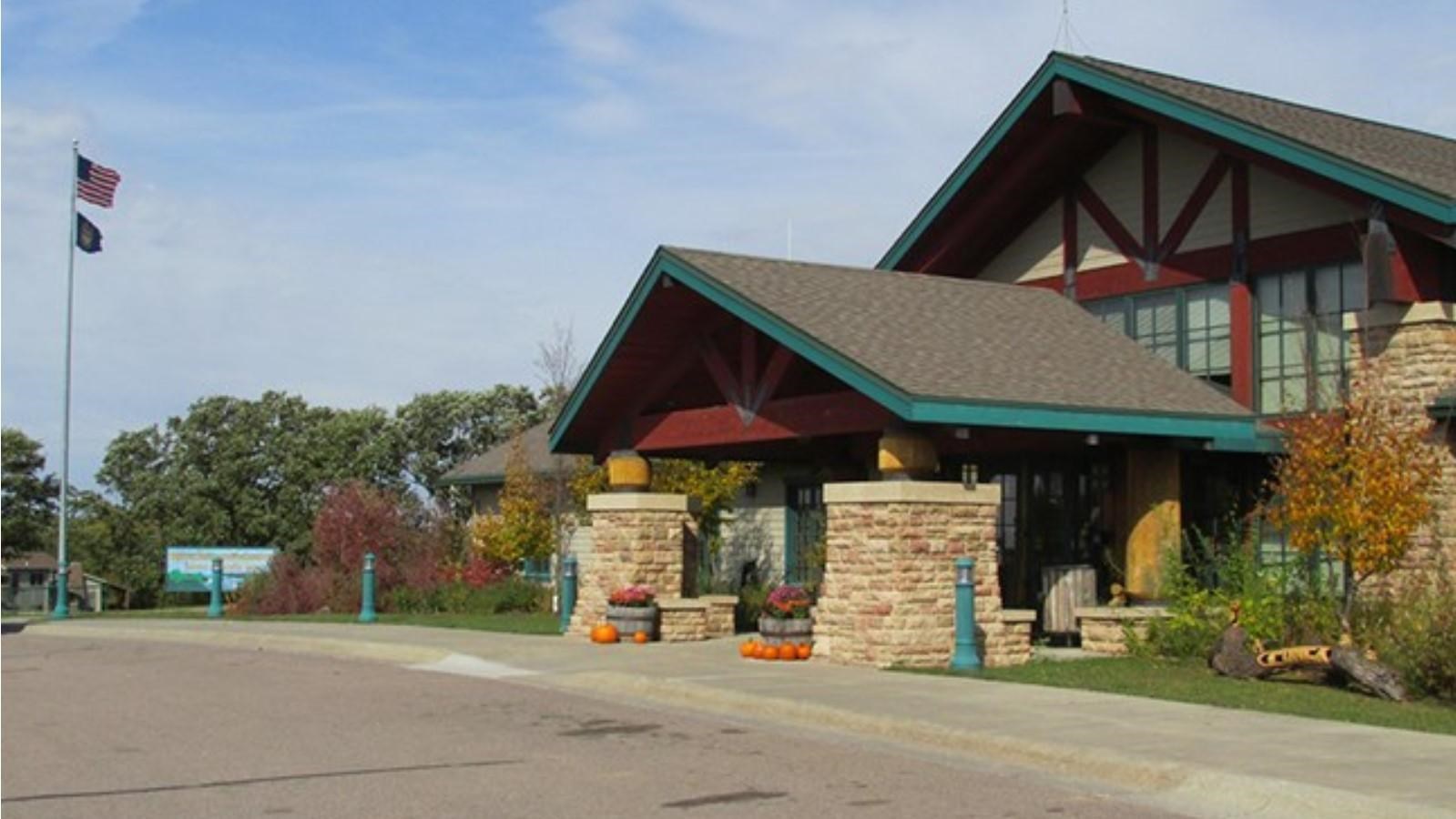 Ponca State Park visitor center with wood and stone structures. Roof has turquoise lining.