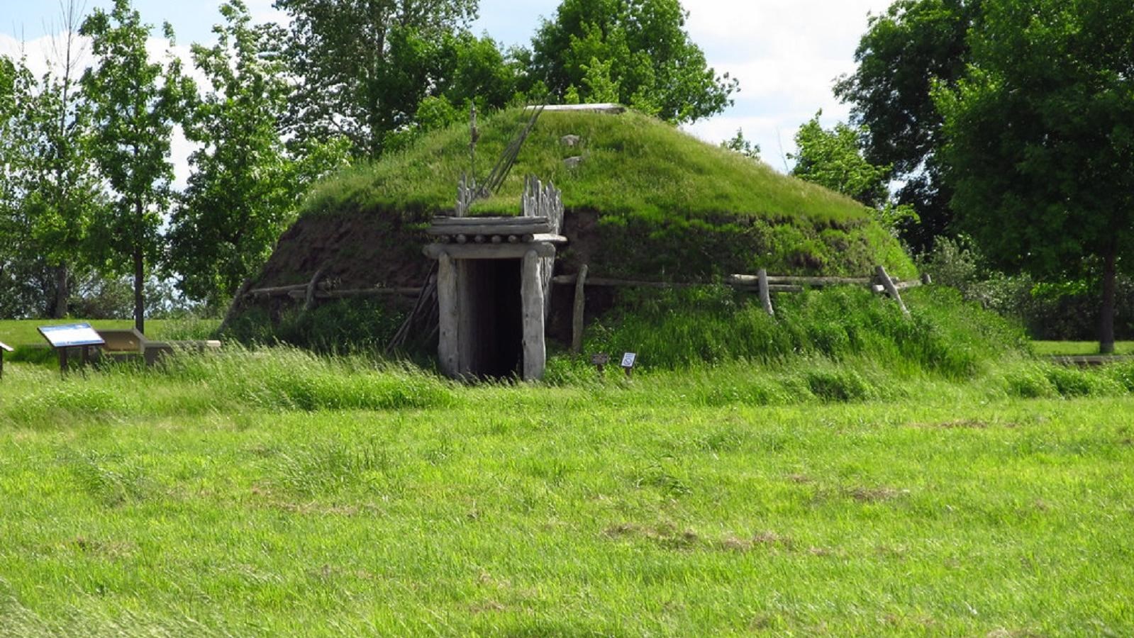 A large dome-shaped earth structure covered in green grass