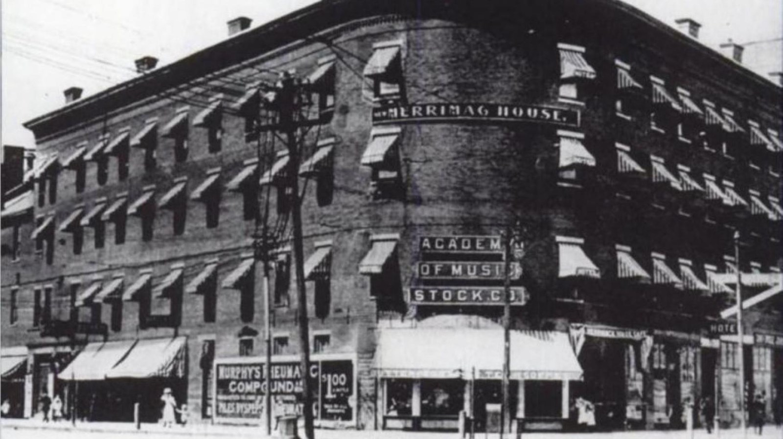 A black and white photograph of the three story building, Merrimack House, on the corner of a block.
