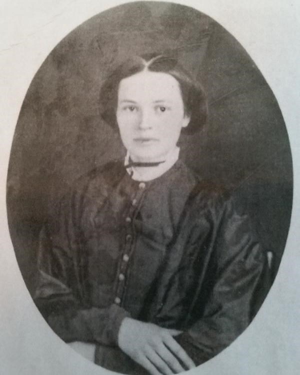 a young woman sitting with her hands folded in lap