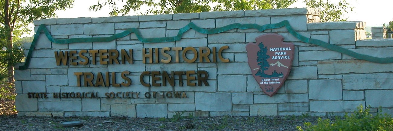 A stone sign with the entrance to the visitor center.