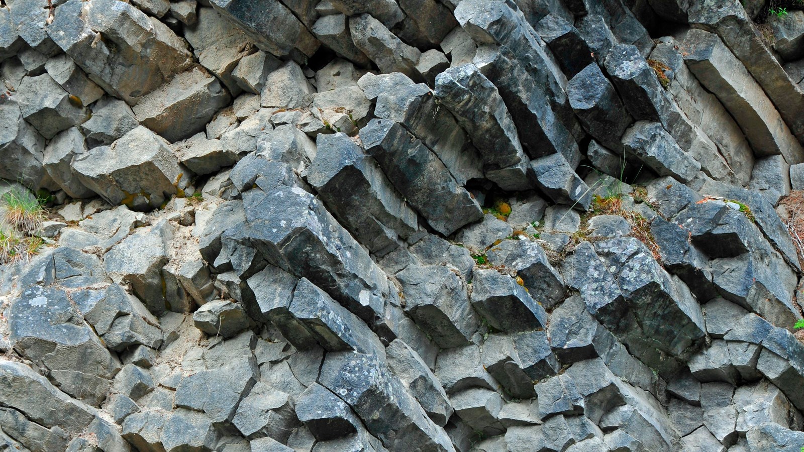 Grey rocks broken up into narrow horizontal columns. 