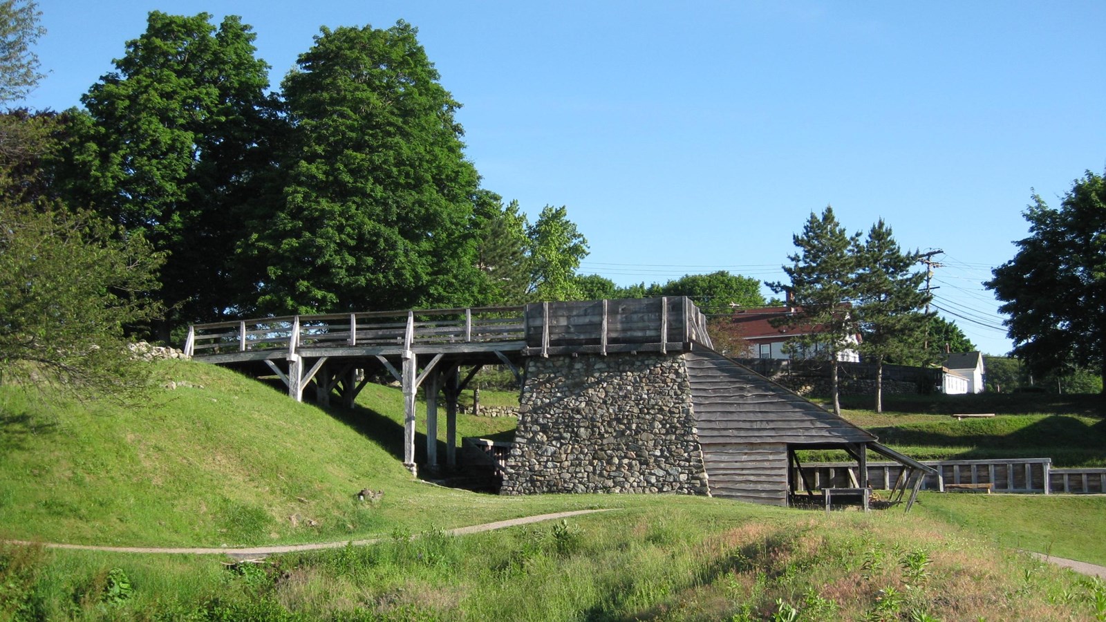 A stone furnace topped by a wooden bridge and open-air shed on bottom
