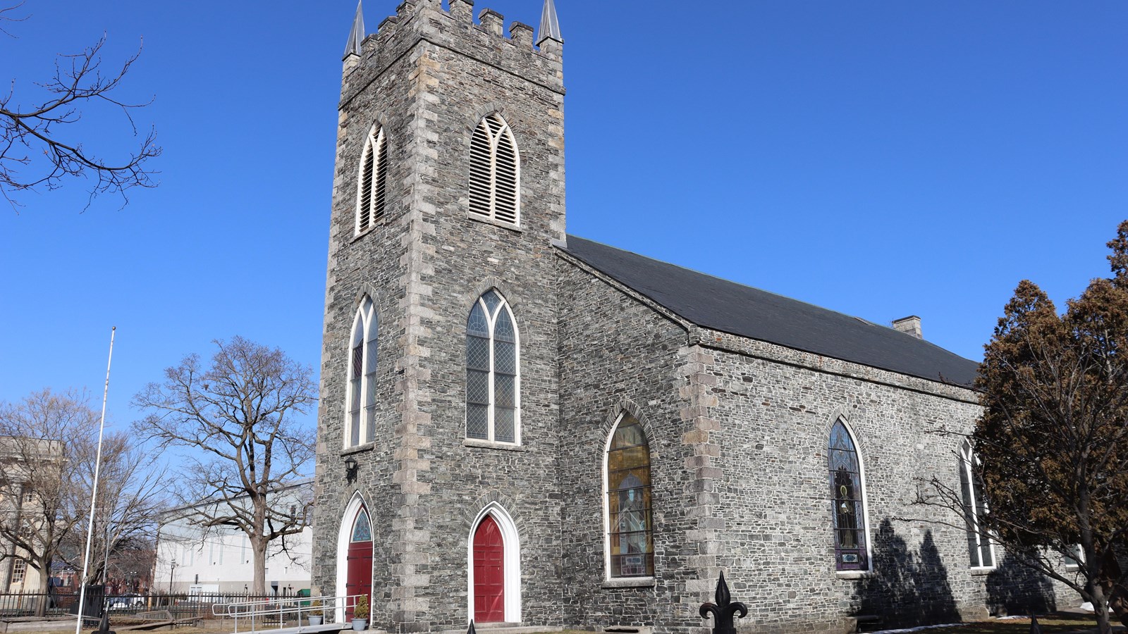 Sideview photograph of the stone walls of St. Anne’s, displaying two of the stained glass windows.