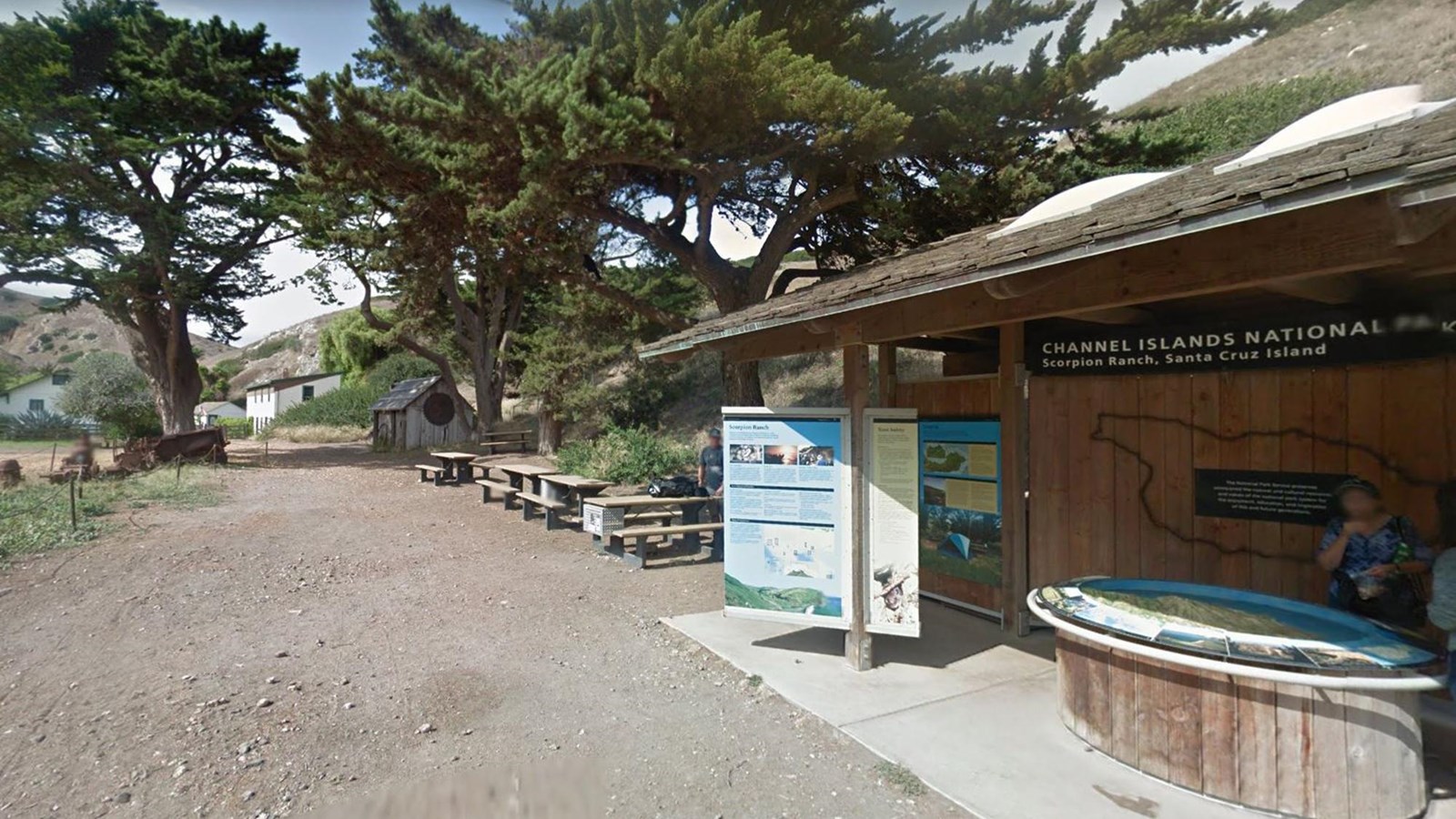 picnic area with table and tall trees and educational exhibits