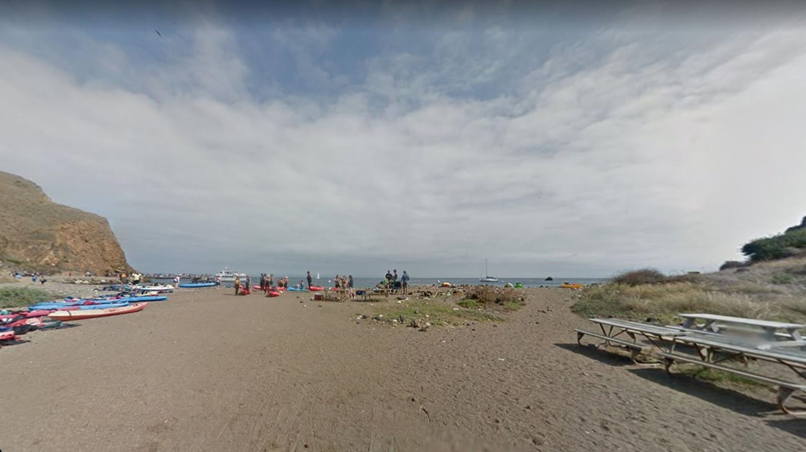picnic tables near beach area with kayakers