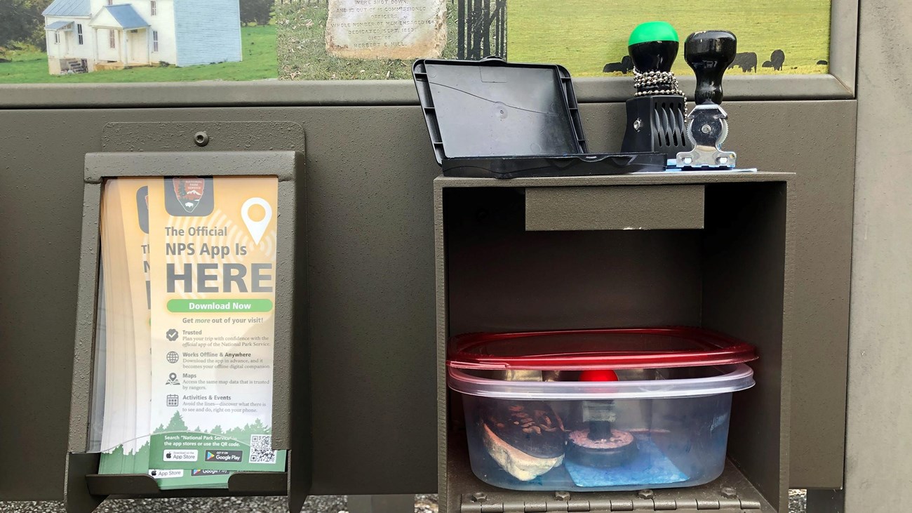 Ink stampers and an ink pad sit atop an open compartment in an information kiosk.