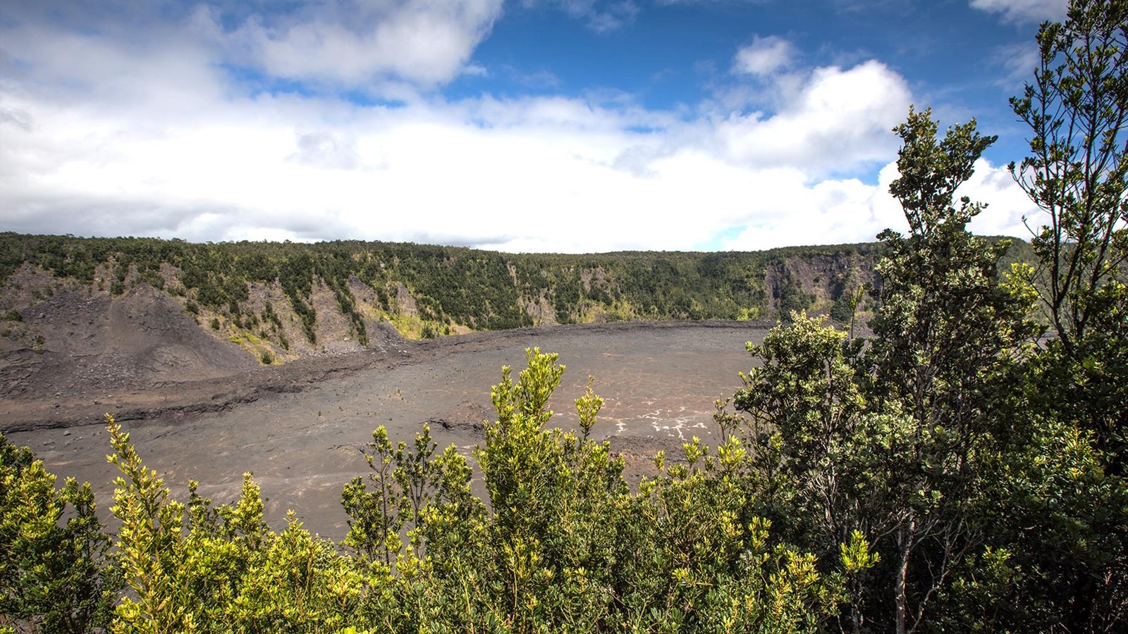 Overlook into a volcanic crater with trees in the foreground