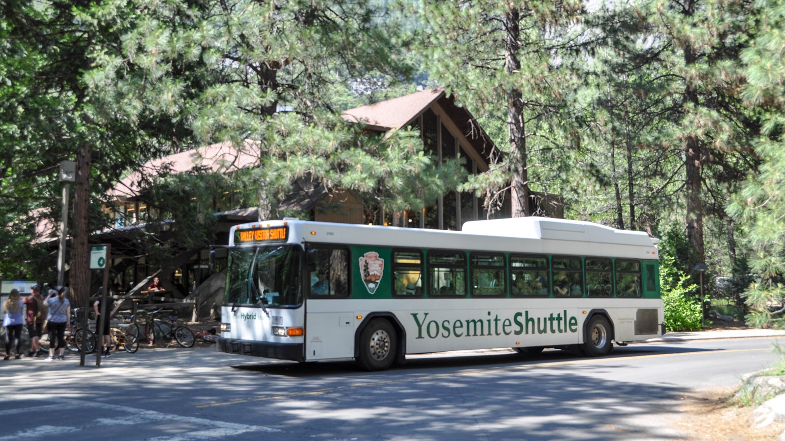 Bus pulled up to stop with wooden building in background