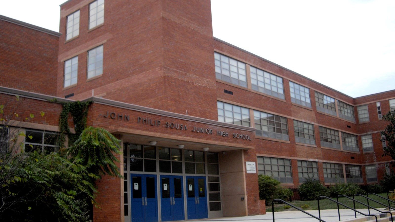 Photo of a several story brick school. 