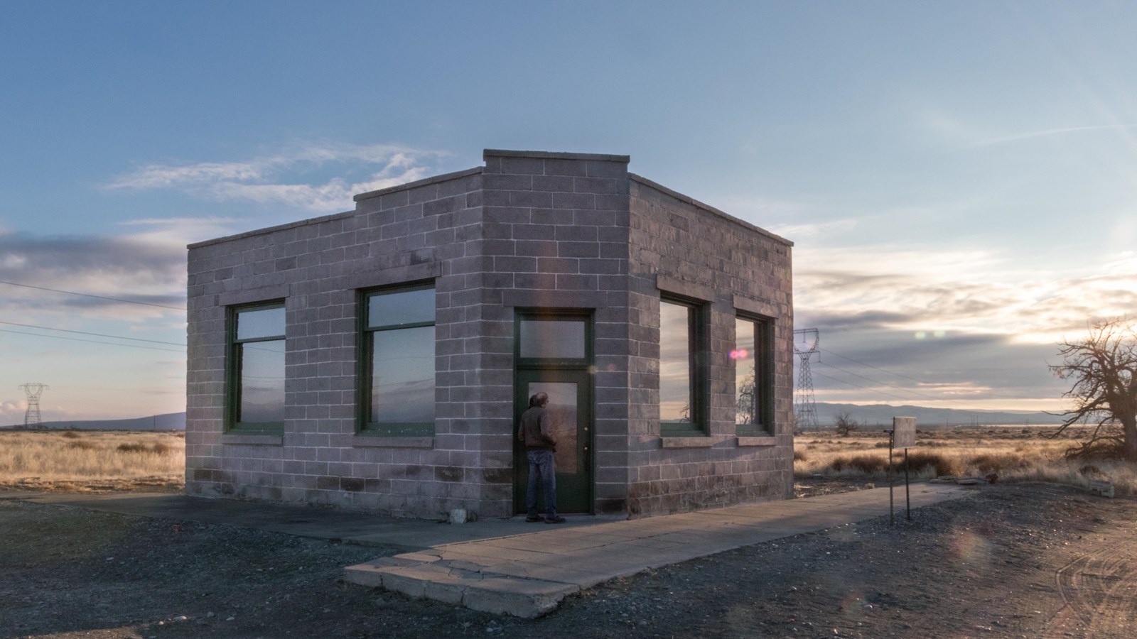 Color photograph of a one-story white neoclassical building surrounded by a bright desert