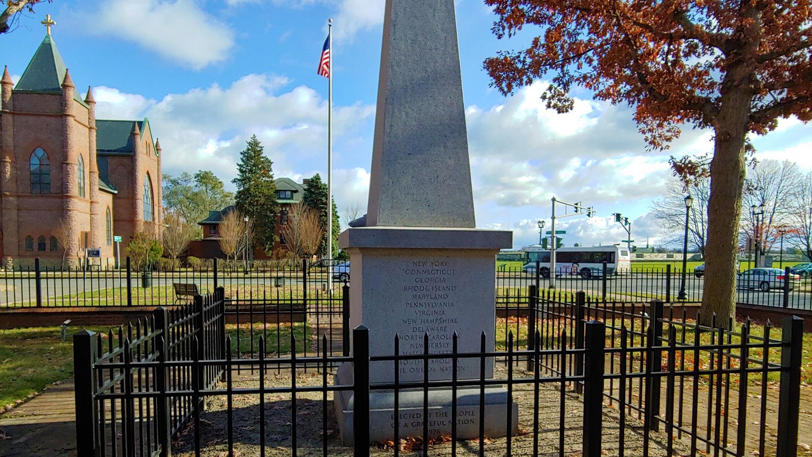 A tall obelisk with an iron fence surrounding it.