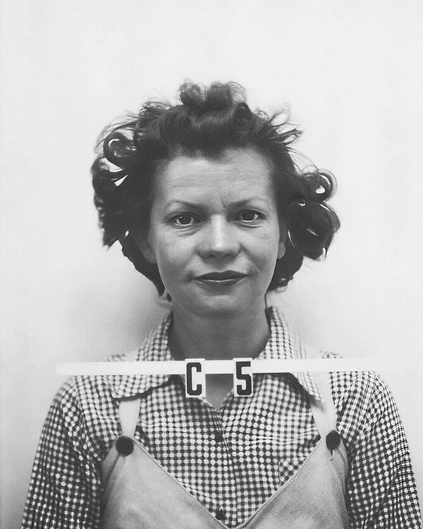 Black and white ID photo of a woman wearing a checkered shirt with “C5” written below her neck.