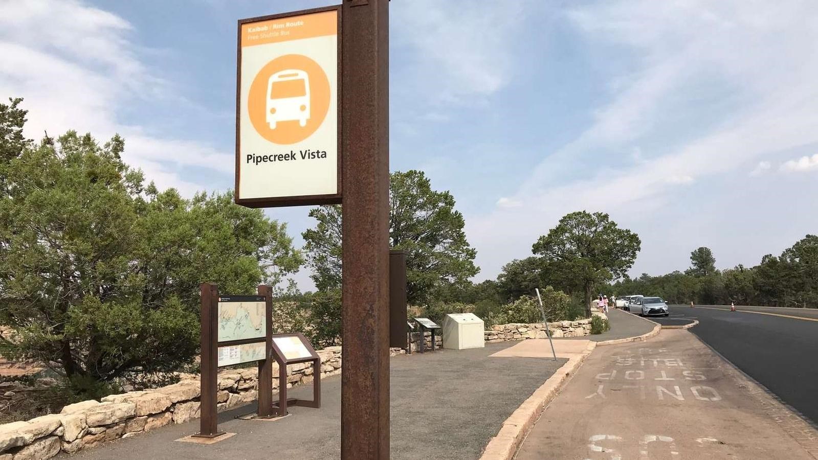 An empty bus stop with an orange and white sign