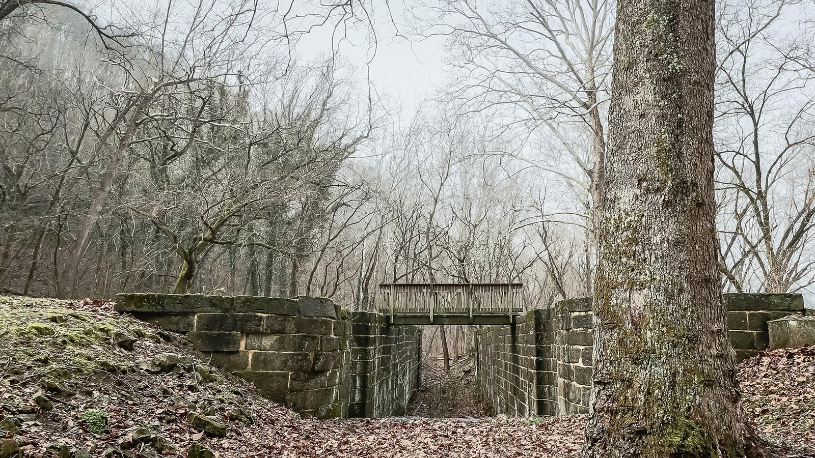 A look through a lock. The lock walls are on the right and left. A dark winter day.