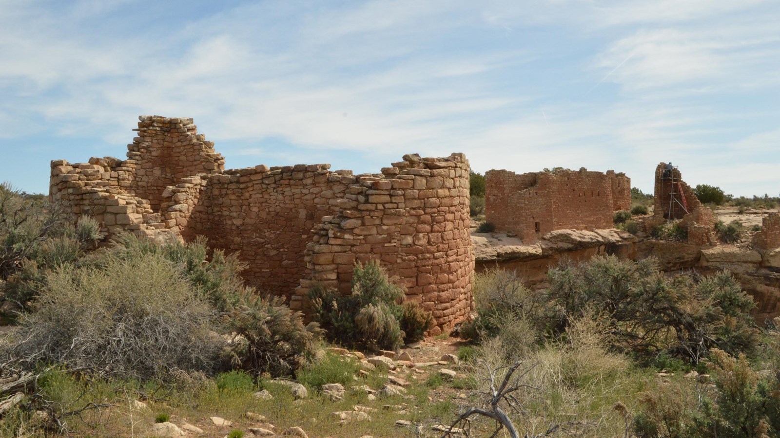 remains of a rectangular stone structure, with another structure in the background