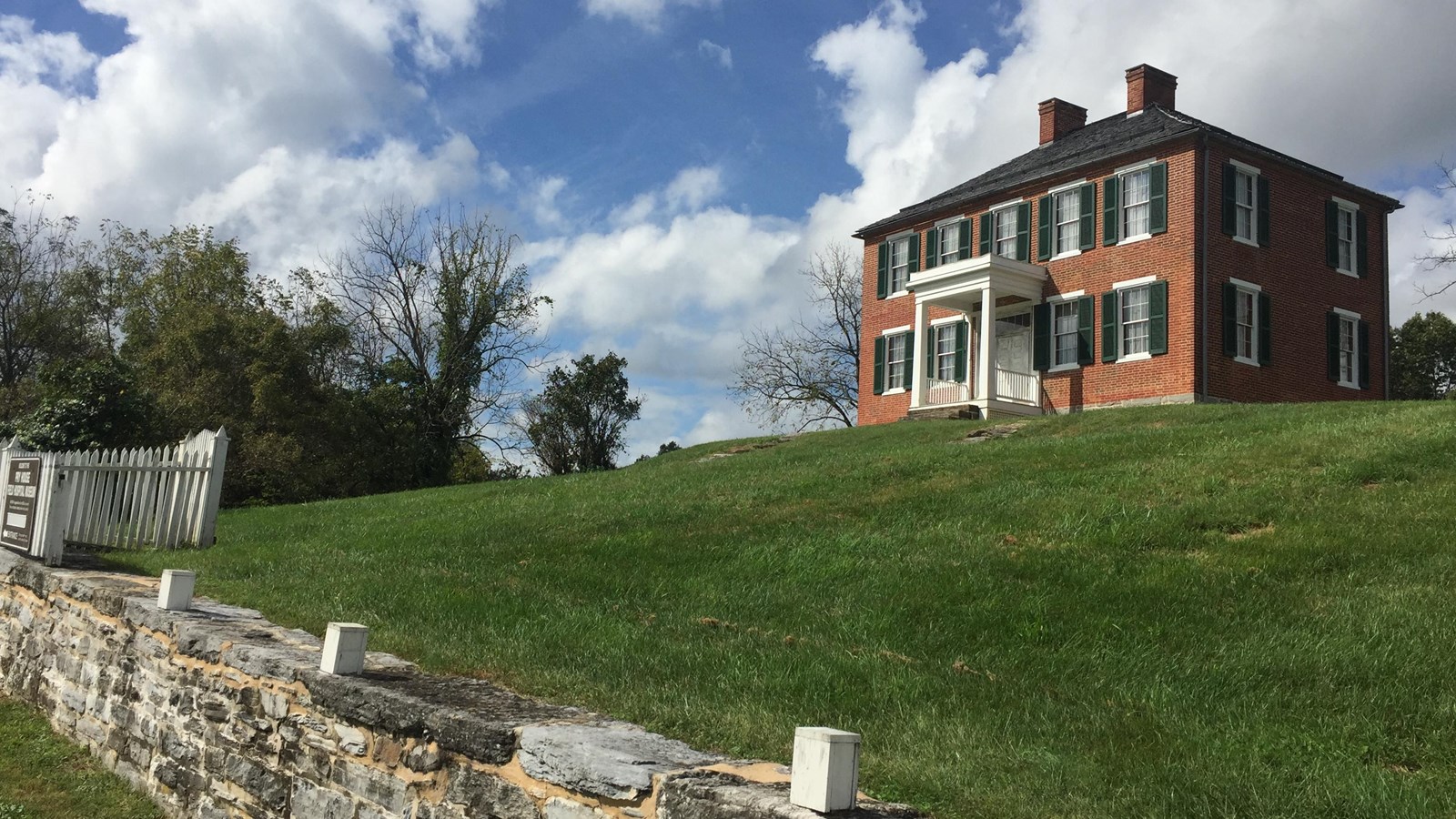 two story red brick house on a hill