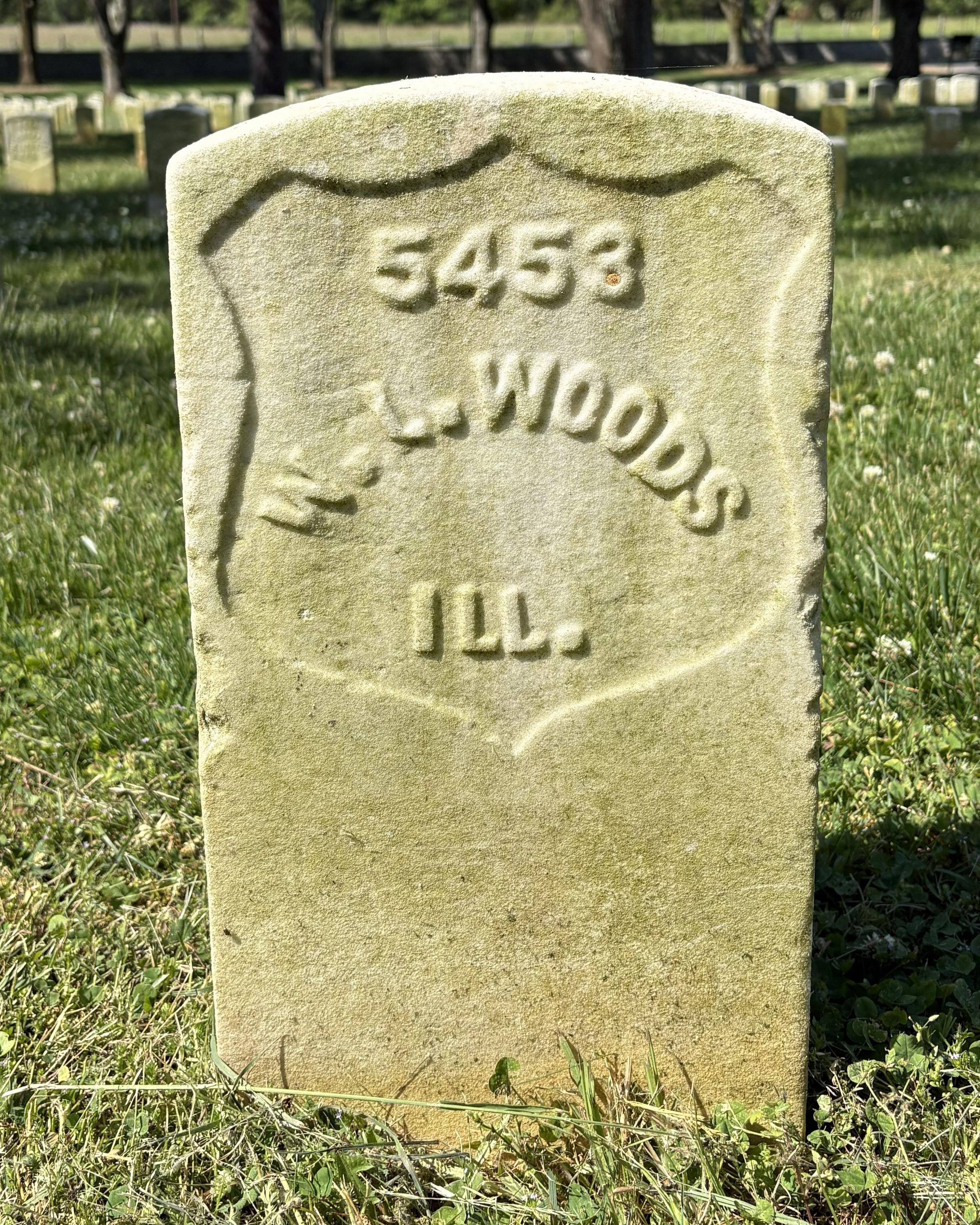 Marble headstone belonging to Washington L Woods, US Veteran. 