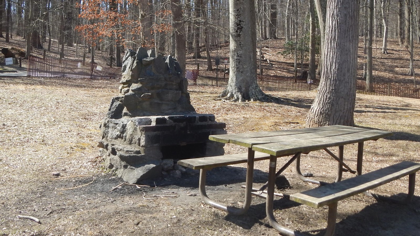 A stone chimney and picnic table