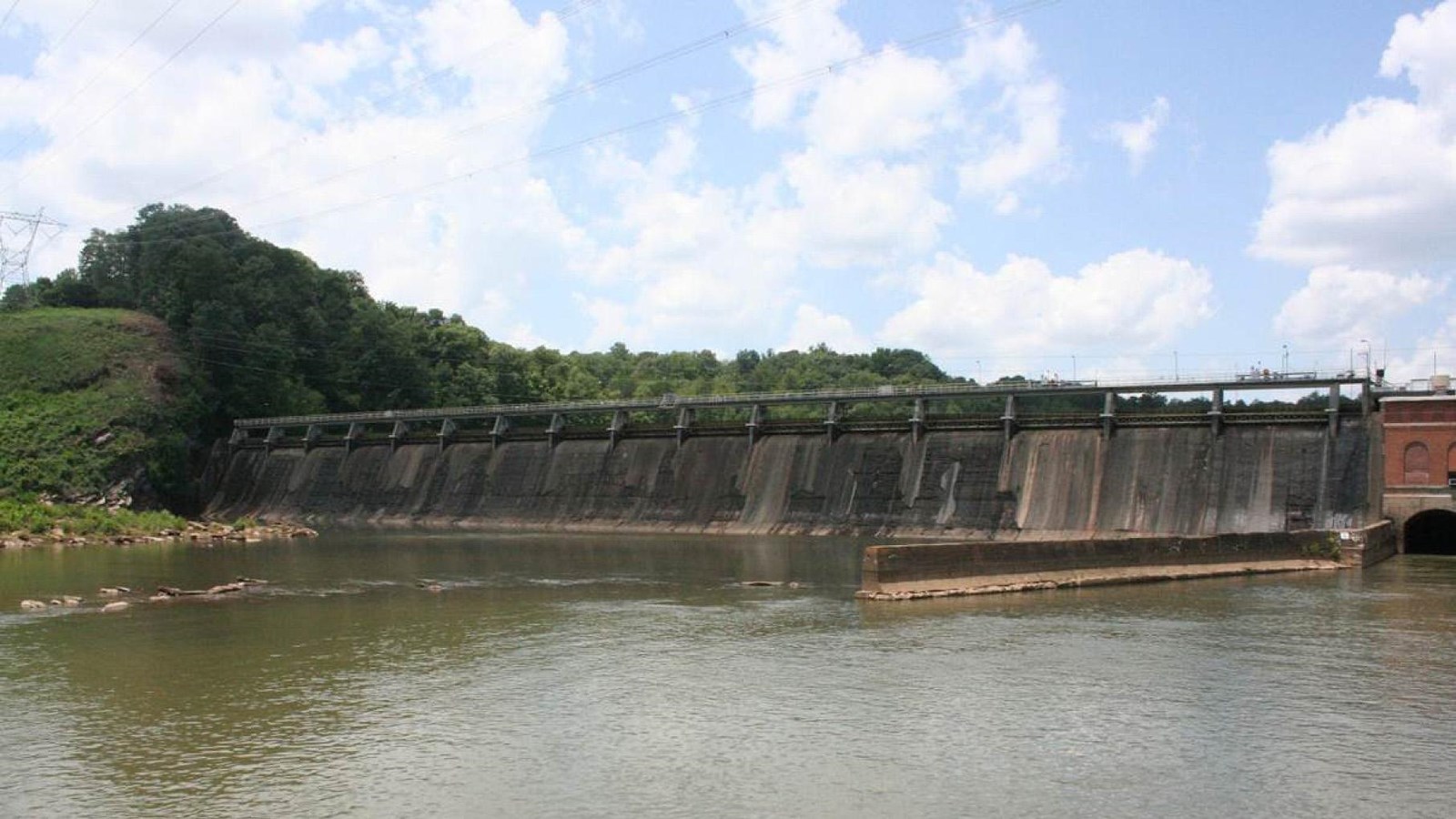 Downstream view of dam showing the 16 spillways and one end of brick powerhouse on the right.