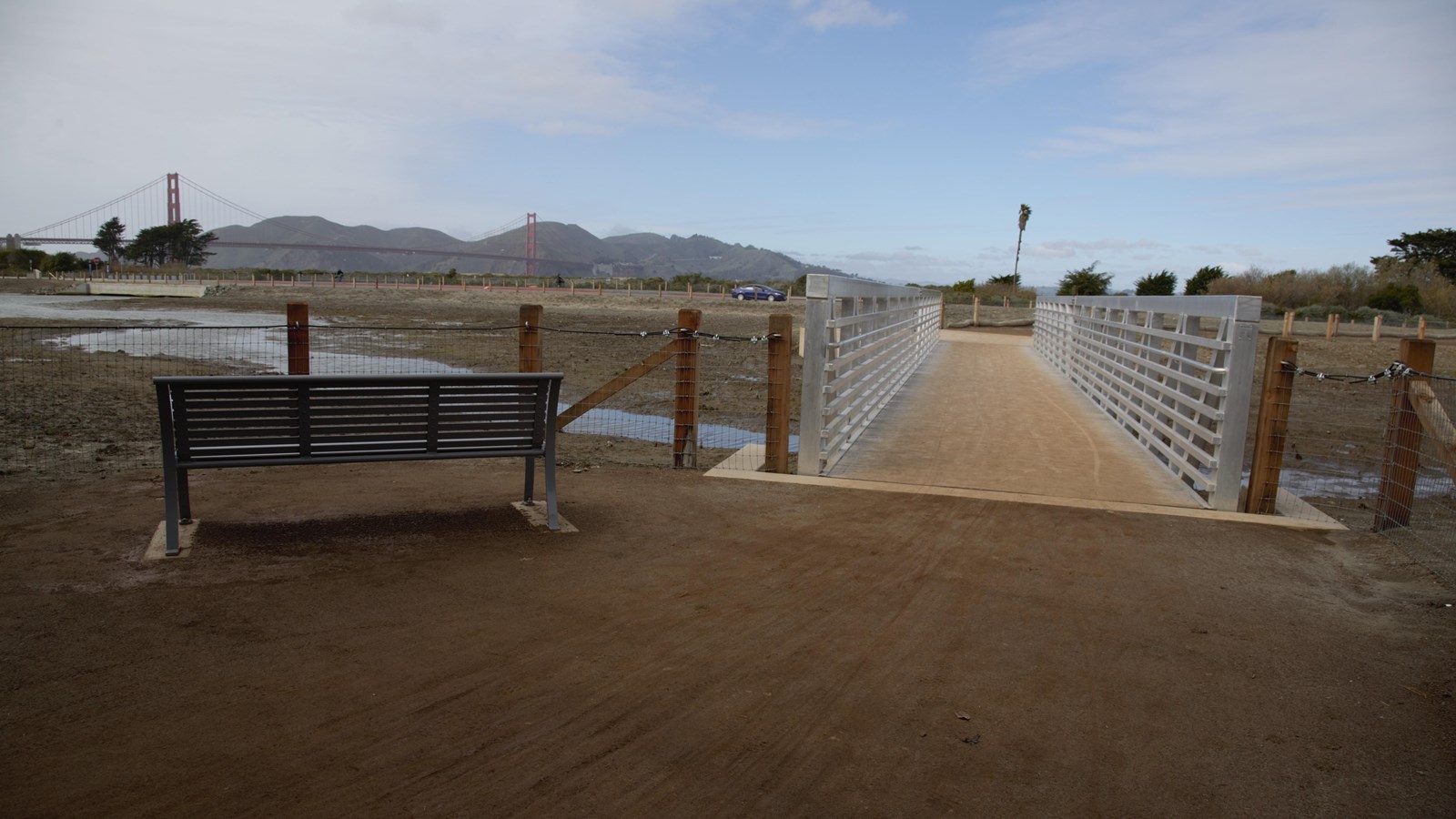 A bench sits next to a walkway overlooking the restored Quartermaster\'s Reach marsh.