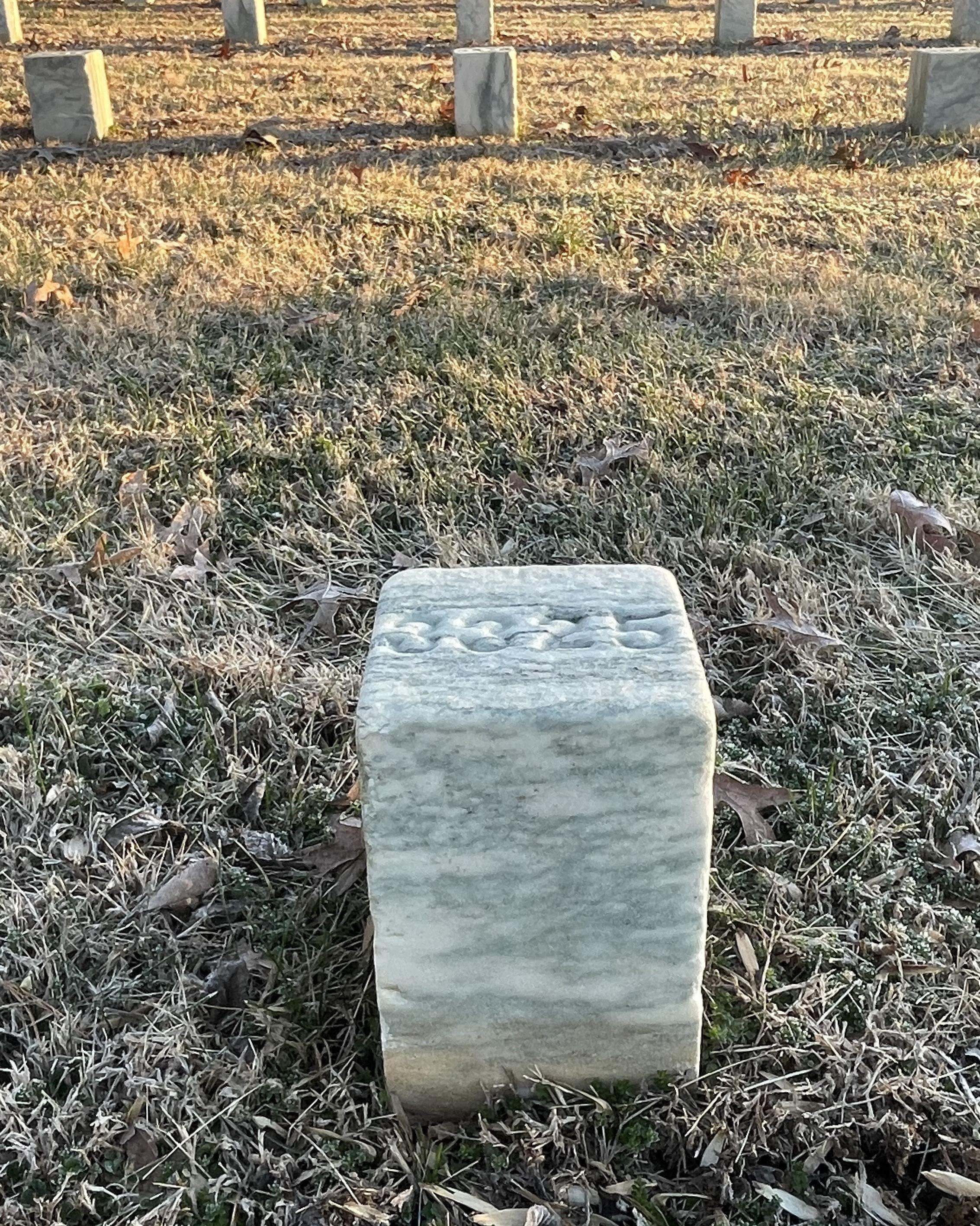 Short, marble headstones in rows. 