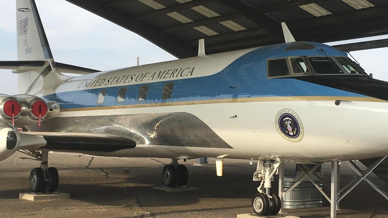 A small presidential plane once designated Air Force One sits under a protective shelter.