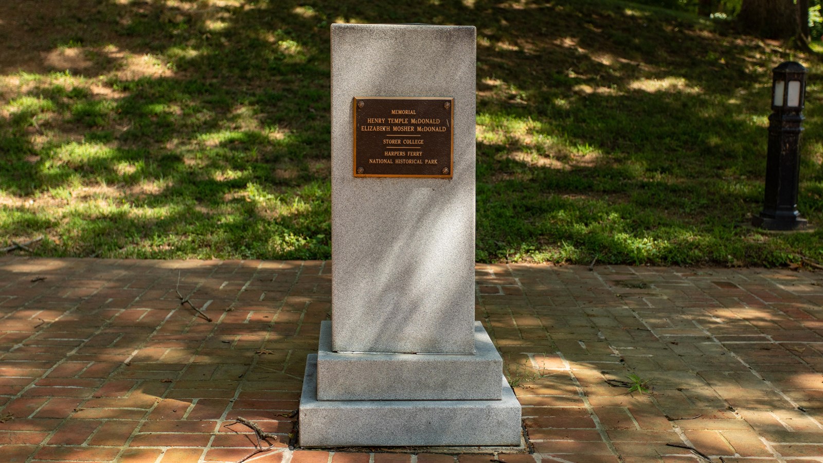 Granite upright rectangular monument, oriented vertically, with bronze plaque on front