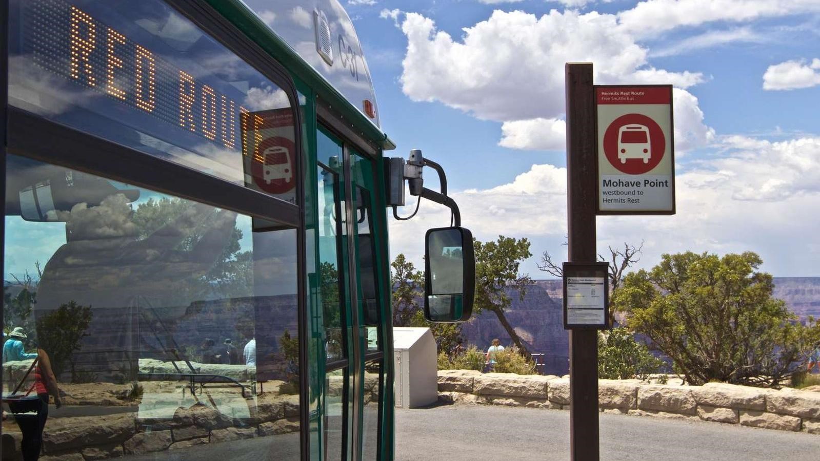 A close up image of the front of shuttle bus next to a sign