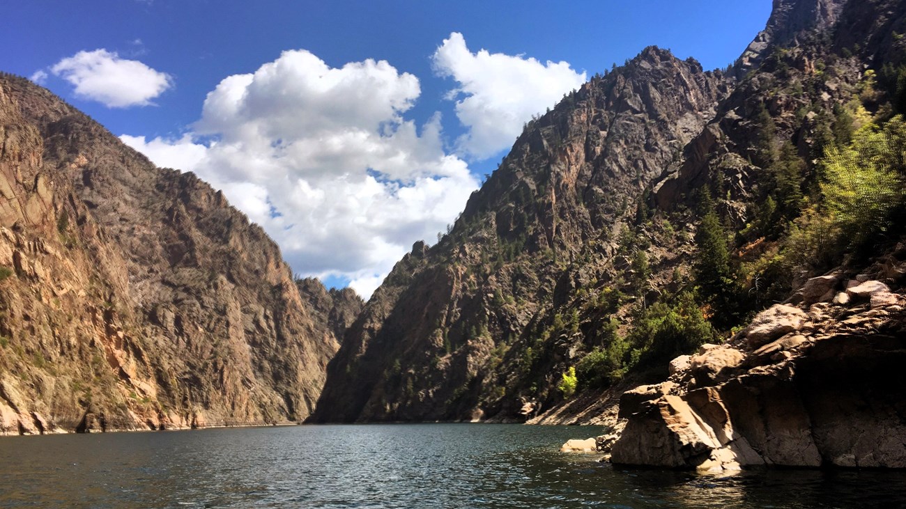 Tall canyon walls and rocky shoreline along a reservoir