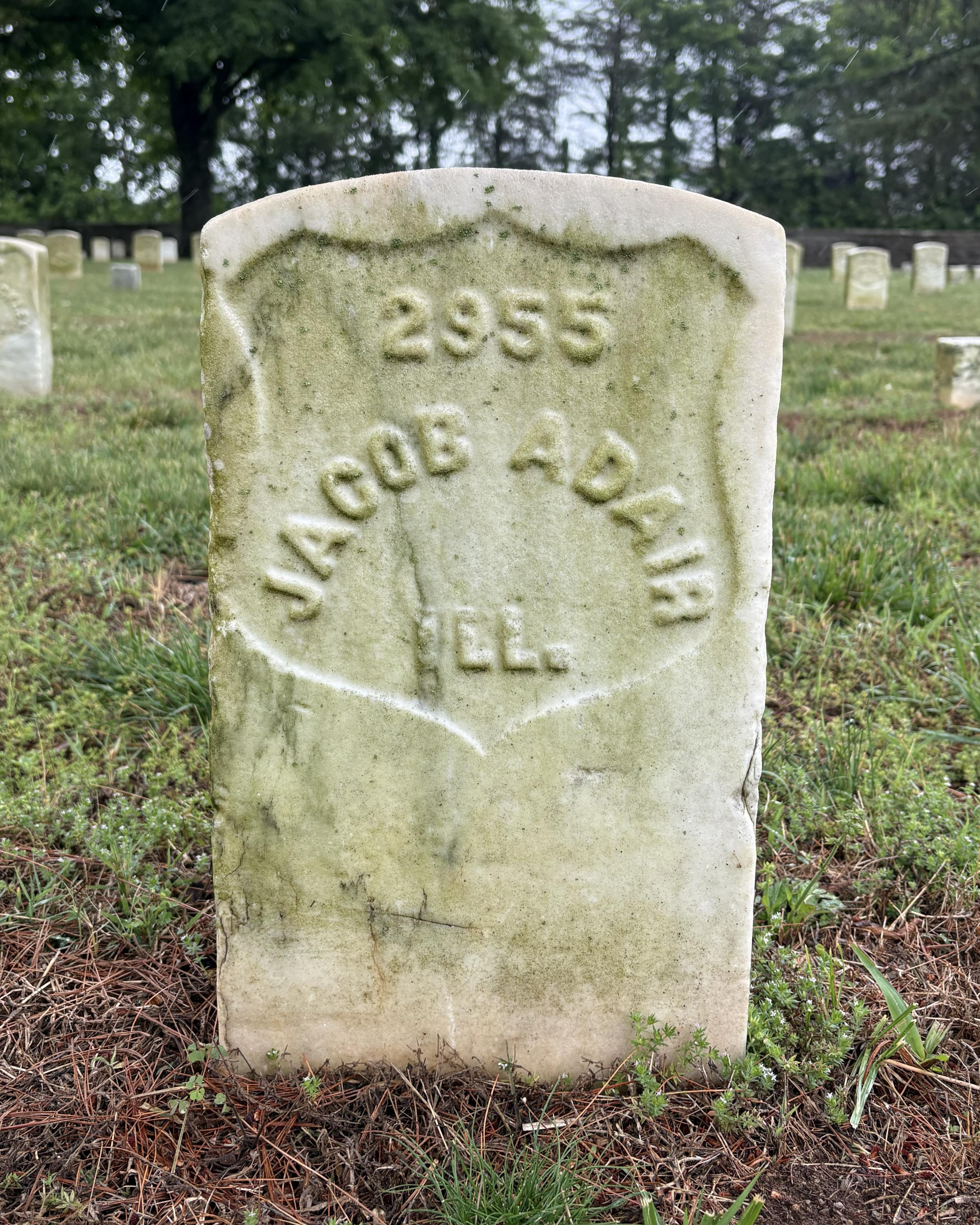 Marble headstone with the name "Jacob Adair" inscribed on its face. 