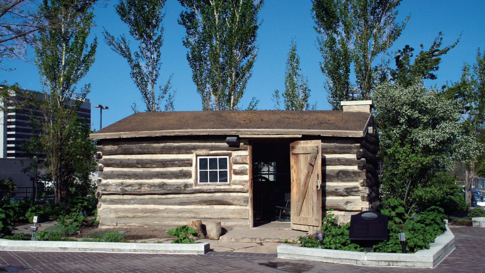 A historic small house, built of rough timber logs.