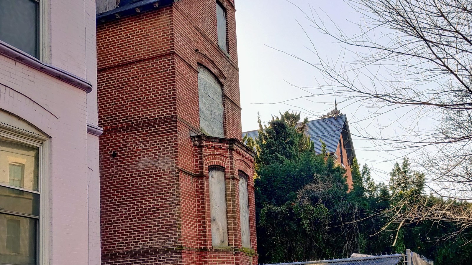 Photo of a large brick house with shuttered windows. 